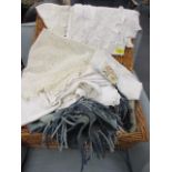 A hamper containing vintage linen, napkins and a woollen rug