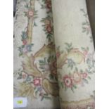 A large machine woven, cream ground rug having a floral design and tasselled ends, 110" x 120"