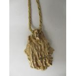 A 9ct gold irregular shaped pendant on a 9ct gold, rope twist chain