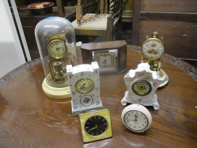 Seven clocks to include two early 20th century china examples decorated with flowers, two