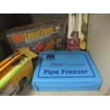 A group of boxed tools to include a lazer level, a Polar pipe freezing kit, along with a fire