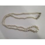 A graduated pearl single strand necklace, approximately 20" in length on a 14ct gold clasp, set with