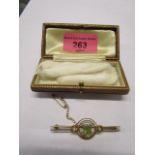 A 15c yellow gold Victorian bar brooch set with a central peridot surmounted by split seed pearls,