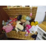 A wicker basket of dolls and bears