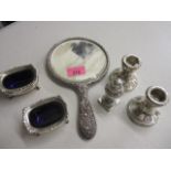 A pair of silver salts, a silver pepperette, a pair of silver candlesticks and a white metal