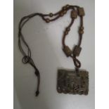 A Chinese carved jade pendant plaque, rectangular shaped on a woven cord necklace with carved jade