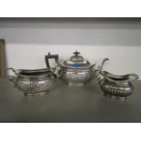An Edwardian silver three pierce tea set by A & J Zimmerman of London shape with gadroon to lower