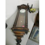 An early 20th century walnut and ebonized Vienna style wall clock, with enamelled Roman dial with