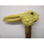 An early 20th century parasol with a carved ivory handle fashioned as a rabbits head, on a Malacca