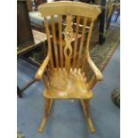 A modern cherry wood Windsor wheel back, rocking chair with makers signature and date 11/2/92