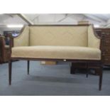 An early 20th century walnut sofa having a fluted crest, arms and supports, with an upholstered