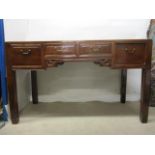 A 19th century Chinese elm desk having a mitred top over three drawers, with brass handles, raised