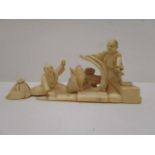 An early 20th century Japanese carved ivory group with three men, a fish and various objects, 1 3/4"