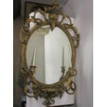 A Victorian gilt gesso girondale having an oval mirror set in a moulded frame with scroll, foliage