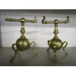 In the style of Christopher Dresser - a pair of Arts & Crafts Aesthetic movement brass fire dogs,