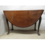 A George III mahogany drop leaf table having a gadrooned, carved edge and D shaped fall flaps,