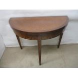 A 19th century continental mahogany and marquetry demi-lune card table, having a foldover top,