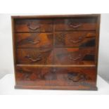 An early 20th century Japanese table top chest with mixed veneers, marquetry ornament, five short