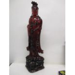 A 20th century Chinese amber coloured figure of Quan Ying, wearing robes and pouring out a vessel of