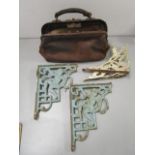 A group of four painted cast iron wall brackets and a vintage leather nurse's Gladstone bag