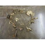 A 9ct gold charm bracelet with various gold and yellow metal charms, 35g