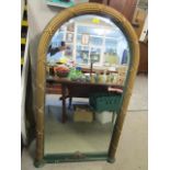 A gilt and green arched framed pier wall mirror with a bevelled glass plate, 52" x 29" 2/8"