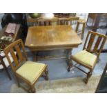 A 1930s oak draw leaf dining table with carved ornament and bulbous columns, raised on block feet,