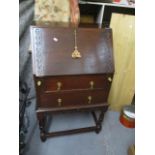 A mid 20th century oak bureau having two drawers