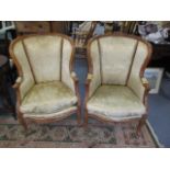 A pair of early 20th century French walnut armchairs with beige floral upholstery