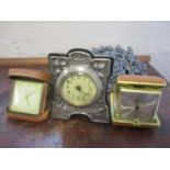 An early 20th century silver fronted dressing table clock, together with two travelling clocks