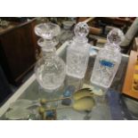 Three cut glass decanters together with a pair of servers