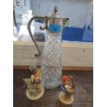 A silver plated and cut glass claret jug, together with two Hummel figures