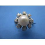 A white gold coloured metal ring fashioned as a flower, set with a pearl, eight diamonds and eight