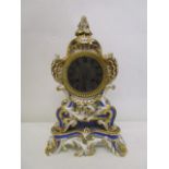 A late 19th century French porcelain cased mantle clock decorated with scrolled, foliage and