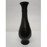 An oriental archaistic bronze vase, pear shaped body on a flared foot, tall slender neck with