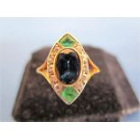 An 18ct gold lozenge shaped ring set with a sapphire, flanked by two emeralds and ten small