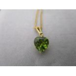 A Mappin & Webb 18ct gold pendant set with a heart shaped peridot, the suspension ring, set with a