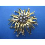 A yellow gold coloured metal flower brooch set with twenty three diamonds, 47mm dia 22g total in a