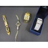 A Gucci ladies wristwatch, a gold coloured Guess ladies cuff watch and two Swarovski ladies watches,