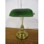 A modern brass desk lamp with a green glass shade