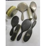 A silver three-piece dressing table mirror and brush set, a pair of silver backed brushes, and a