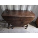 A 1930s oak gateleg table having barley twist supports 30"h x 42"w