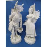 A pair of late 19th century white glazed porcelain figures, each of a man and woman carrying a grape