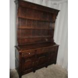 An early 20th century Georgian-inspired dresser having plate rack above and three short drawers