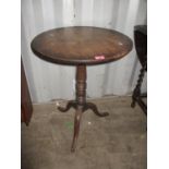 A Georgian oak tilt top occasional table having a turned column and three cabriole legs