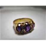 A Victorian yellow metal, three stone amethyst ring flanked by four diamond chips, marks rubbed, 4.