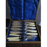 An early 20th century oak cased set of silver collared fish knives and forks