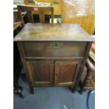 A Georgian oak work cupboard with hinged lid, fitted tray and compartments above twin fielded