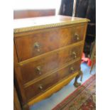 A walnut chest of three drawers above ball and claw feet