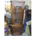 A reproduction mahogany corner cabinet having a dental moulded cornice, astrigal glazed door and a